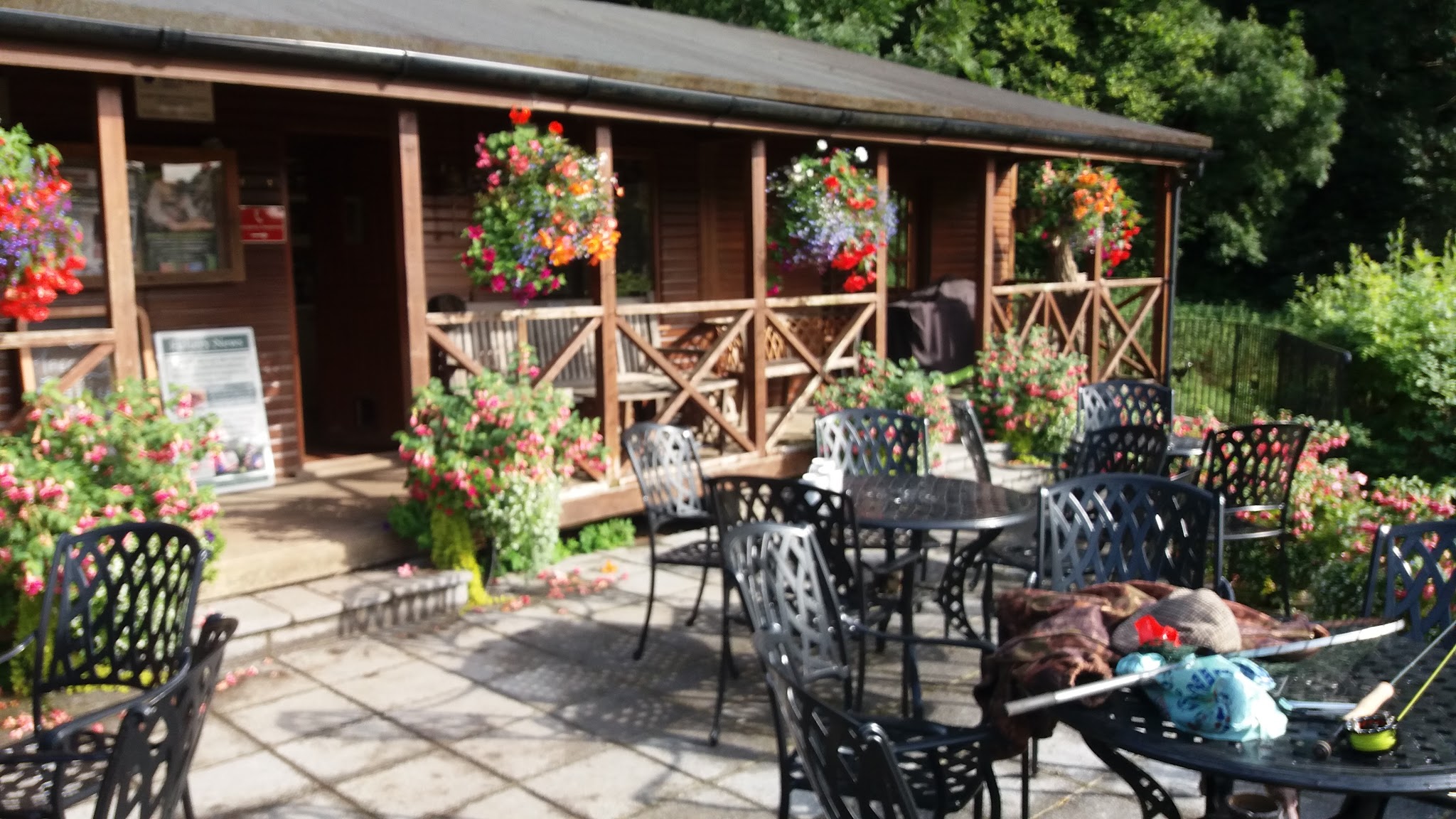 The timber lodge veranda with hanging baskets and patio tables