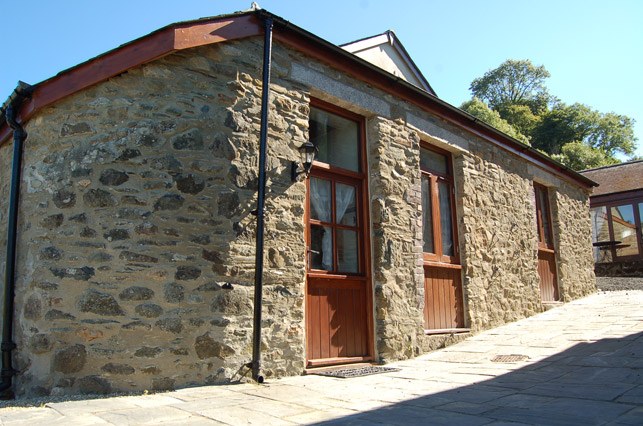 Amelia's Corner, a stone barn apartment with a doorway onto a sunny patio