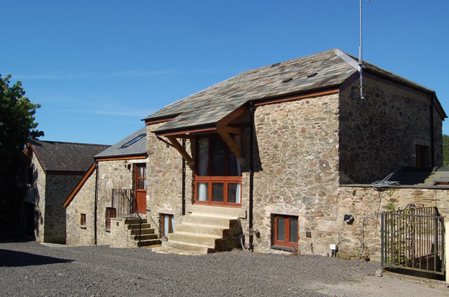 The stone barn with granite steps up to Charlotte's Barn Top Apartment