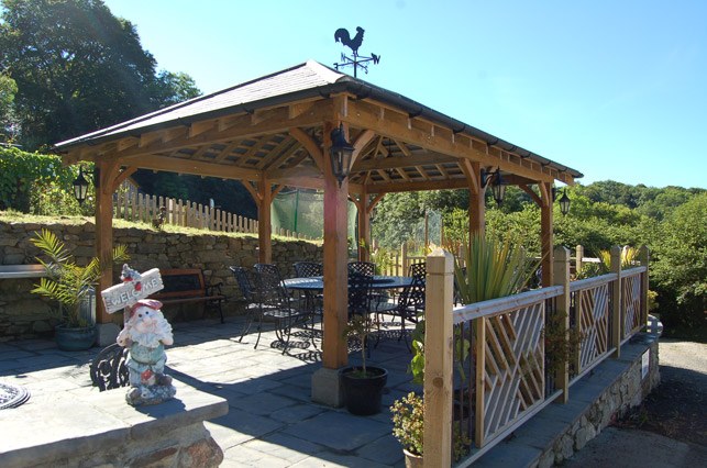 The oak gazebo with its slate roof, tables and chairs in the courtyard