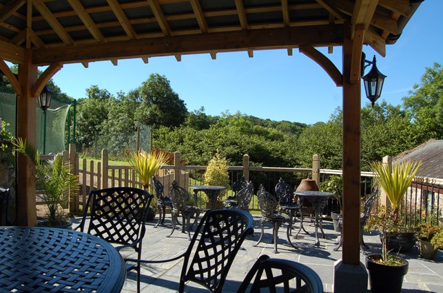 Patio tables under the oak gazebo, with gardens beyond