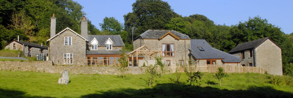 Stone holiday cottages across a sunny lawn