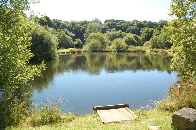 A still fly lake with a fishing platform in the foreground
